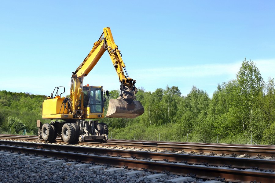 Rail excavator working with rubble. Excavators machine excavate on railway.